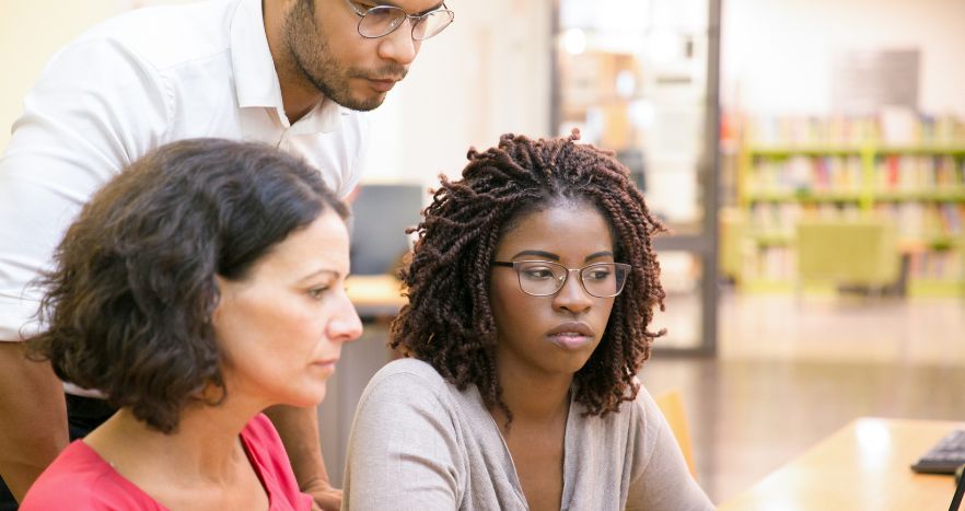 Professores olhando dados da educação em um computador.