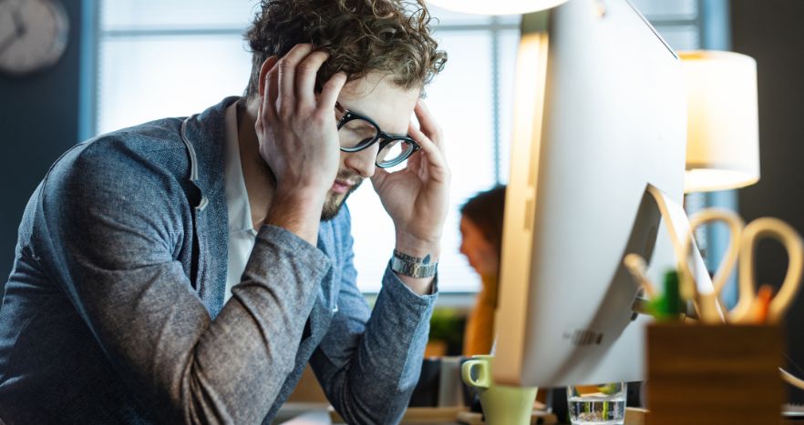Homem preocupado com os prejuízos em sua empresa causados por ataque cibernético.